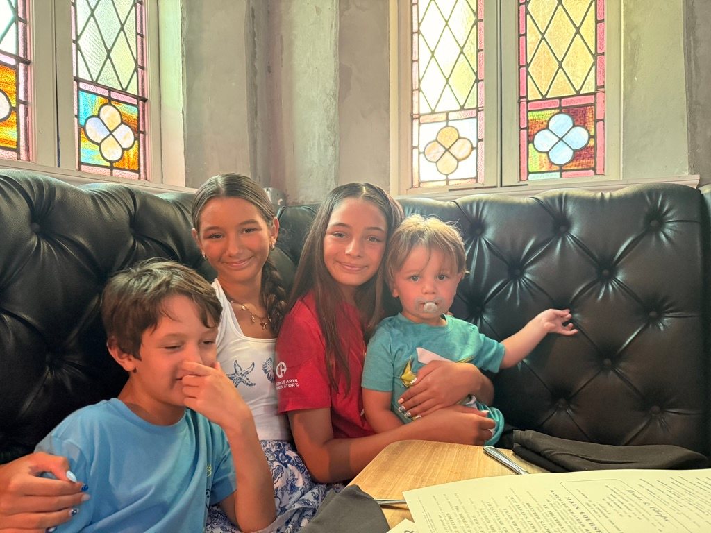 Daniel's four kids together in a restaurant booth