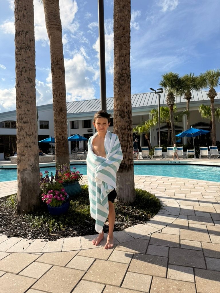 Daniel's son wrapped in a towel by the pool
