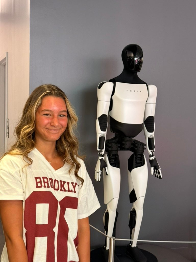 Daniel's daughter standing next to a humanoid robot